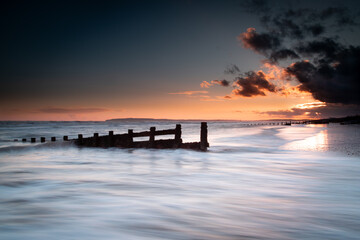 Long exposure landscape photograph at Camber sands beach on a warm evening, Image shows the...