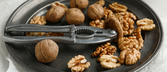 Plate of tasty walnuts on table