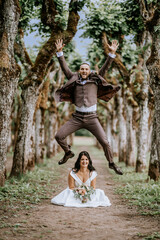 Valmiera, Latvia- July 28, 2024 - In a whimsical wedding moment, the groom leaps high above the...