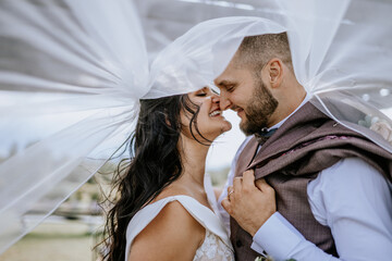 Valmiera, Latvia- July 28, 2024 - Close-up of a bride and groom facing each other, their heads...