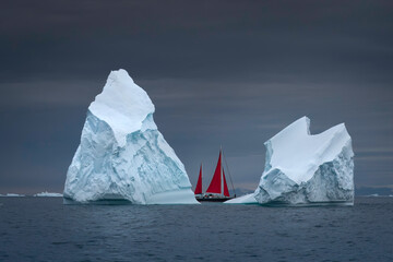 2 large icebergs with red sailboat in between, Ilulissat Greenland - obrazy, fototapety, plakaty
