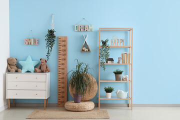 Interior of stylish children's room with wooden stadiometer, chest of drawers and toys - obrazy, fototapety, plakaty