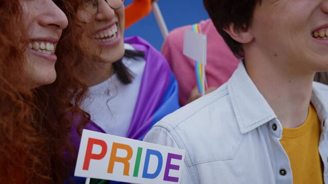 Diverse group of laughing young people taking cheerful selfie for social networks, celebrating gay pride festival month. Community of LGBT having fun friends outdoors 