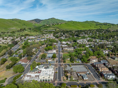 Drone photos over downtown Clayton, California with businesses, green hills and a blue sky