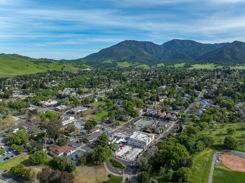 Drone photos over downtown Clayton, California with businesses, green hills and a blue sky