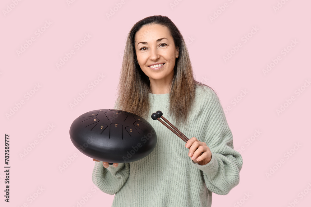 Poster Beautiful mature woman with glucophone and sticks on pink background