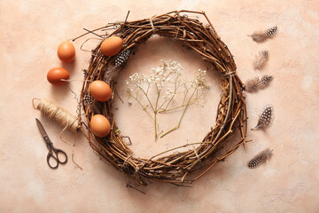 Supplies for creating Easter wreath with eggs and feathers on beige background