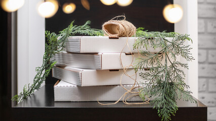 Rustic white cardboard pizza boxes stack with twine and greenery for packaging and branding
