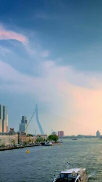 View of Rotterdam cityscape and Erasmus bridge over Nieuwe Maas with ships and boats. Rotterdam, Netherlands. Camera pan