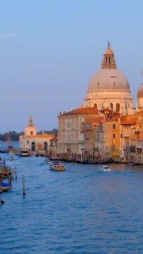Panorama of Venice Grand Canal with boats and Santa Maria della Salute church on sunset from Ponte dell'Accademia bridge. Venice, Italy. Horizontal camera pan