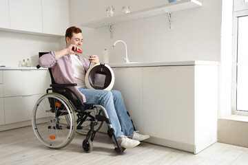 Young man in wheelchair repairing coffee machine at home