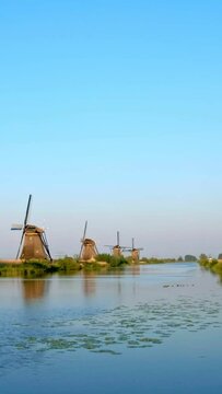 Netherlands rural village scenic view - windmills at famous tourist site Kinderdijk in Holland. Kinderdijk , Netherlands. Camera pan