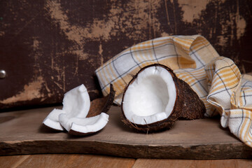 Coconut with white pulp on wooden background..