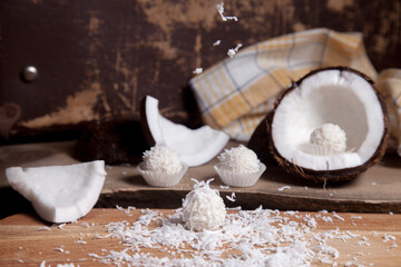 Close up of white candies and coconut with white pulp, coconut chip on wooden background..