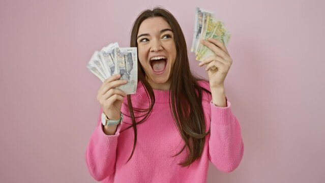 Happy woman holding peruvian soles and us dollars against a pink background, portraying wealth and excitement.