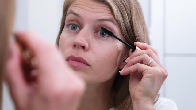 morning routines. young beautiful woman making make up near mirror