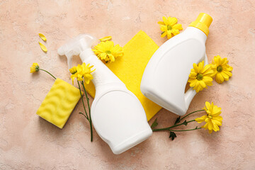 Naklejka premium Set of cleaning supplies and spring flowers on beige grunge background
