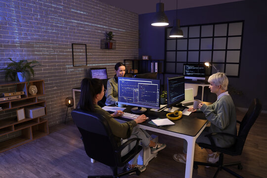 Group of female programmers working in office at night
