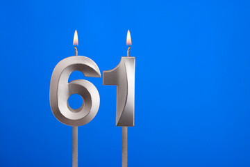Birthday number 61 - Candle lit on blue background
