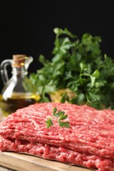 Raw ground meat and parsley on table