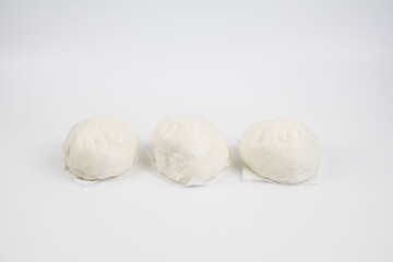 Steamed buns with minced pork on bamboo cutting board. Chinese food dim sum style on white background. Breakfast Asian food.	
