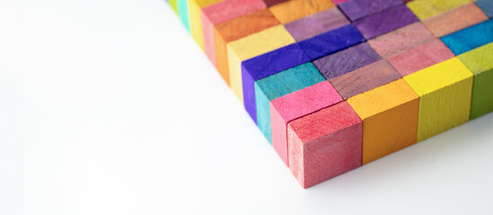 Colorful wooden blocks aligned in a strip on a neutral white background. header, cover mage for something creative or diverse. A Spectrum of multi-colored wooden blocks aligned. 