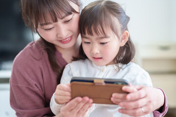 スマートフォンを使う親子　女の子とお母さん - 787659198