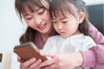 スマートフォンを使う親子　女の子とお母さん - 787659300