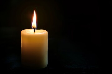 Fototapeta na wymiar Burning candle on a dark background