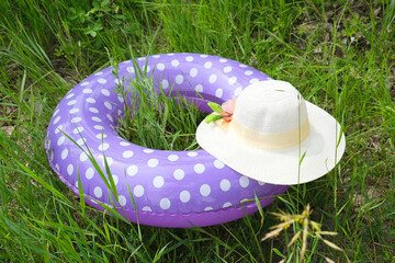 Nature scene with inflatable swim ring on the beach by the river, straw hat. Calming and relaxing. Lazy lifestyle summer holidays travel background