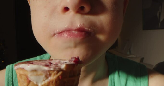 Child licking ice cream. Close-up of child's mouth, a little boy eating a waffle cup with vanilla ice cream and strawberry ice cream. Close up portrait of cute boy eating waffles cone ice cream. 4K