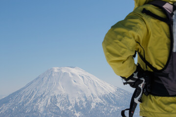 Rear view of japanese male skier standing looking at Mount Yotei winter landscape Niseko Hokkaido