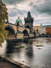 Fototapeta premium Prague, Charles Bridge, view from the river side, realistic photo, cloudy day, green trees in front of buildings, gray sky