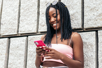 Portrait of a black young woman enjoying in the city using smartphone