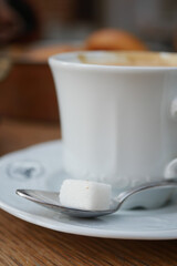 cup of tea and sugar cube on table