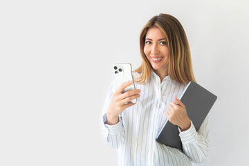 Caucasian businesswoman in formal attire in her office happy and cheerful while using smartphones 