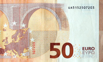 Fragment of one fifty euro money bill. Details of European union currency banknote of 50 euro close up