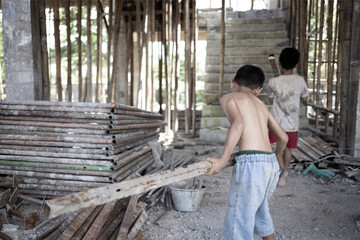 Poor children at the construction site were forced to work. Concept against child labor. The...