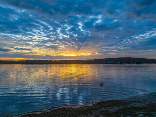 Sunrise over the bay water with clouds and reflections