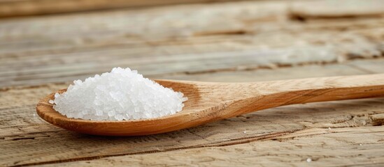 Fototapeta na wymiar White sugar in a wooden spoon on a wooden table.