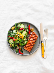 Delicious diet lunch, dinner - grilled salmon and fresh vegetable salad on a light background, top view - 787775111