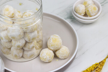 Kue putri salju or snow white cookies, popular hari raya cookies in Indonesia, baked and powdered with icing sugar. Special background for ramadan and eid mubarak. 