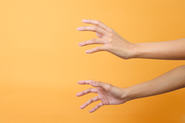 Female's hands trying to grab or reach something isolated over pink background