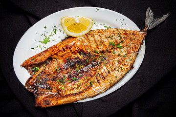 grilled fish on the white plate - 787804347
