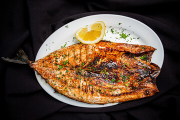 grilled fish on the white plate - 787804387