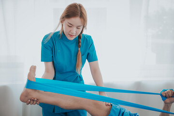 Obraz premium Physical therapy assistance Asian female doctor with senior man in physical therapy rehabilitation or health support Female physical therapist or physical therapist counseling an elderly patient.