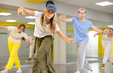 Expressive cool young dancers rehearsing their new dance during training together in studio