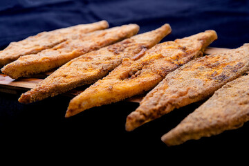 Paplet or pomfret fish fry malvani, konkani and goan style on a black background with garish.