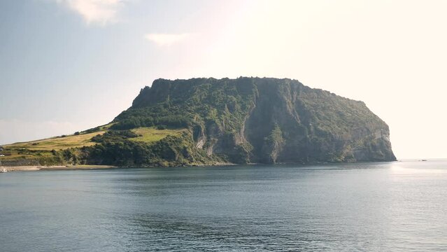 Seongsan Ilchulbong in Jeju Island, Republic of Korea. View of Crater peak in South Korea and tol harubang, hareubang also called stone grandpa. High quality 4k footage