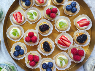 Tiny cupcakes with various fruits. Catering buffet for events. Catering banquet table with different food snacks and appetizers.
